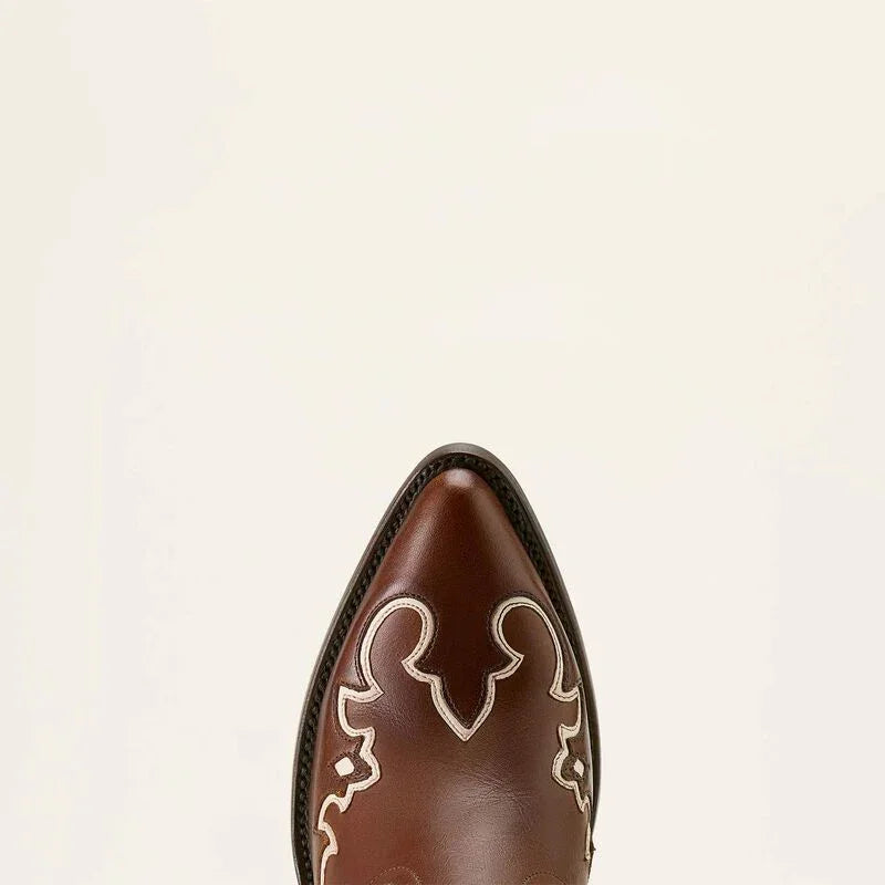 Brown cowboy boot with decorative white patterns on a beige background